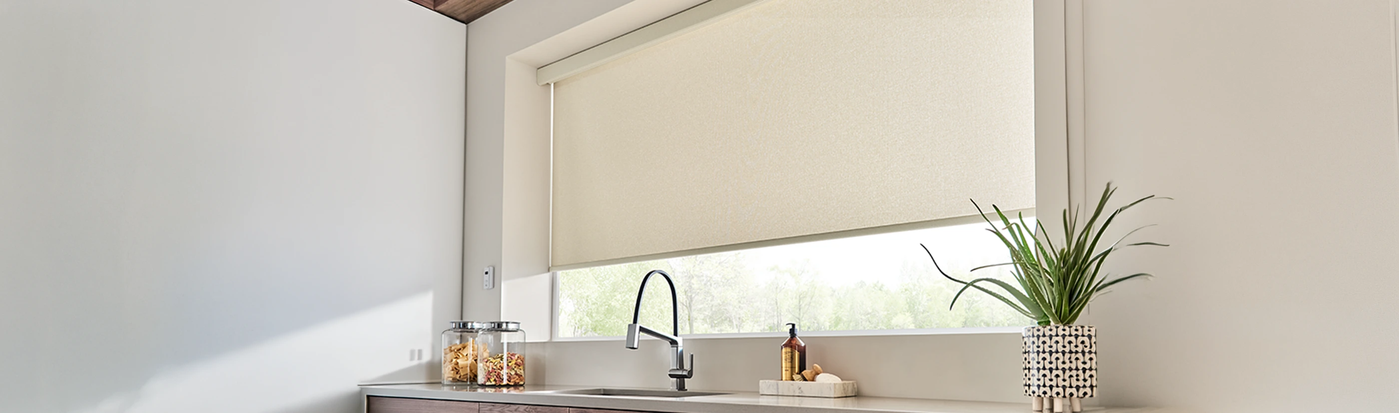 Beige motorized shades above a kitchen sink